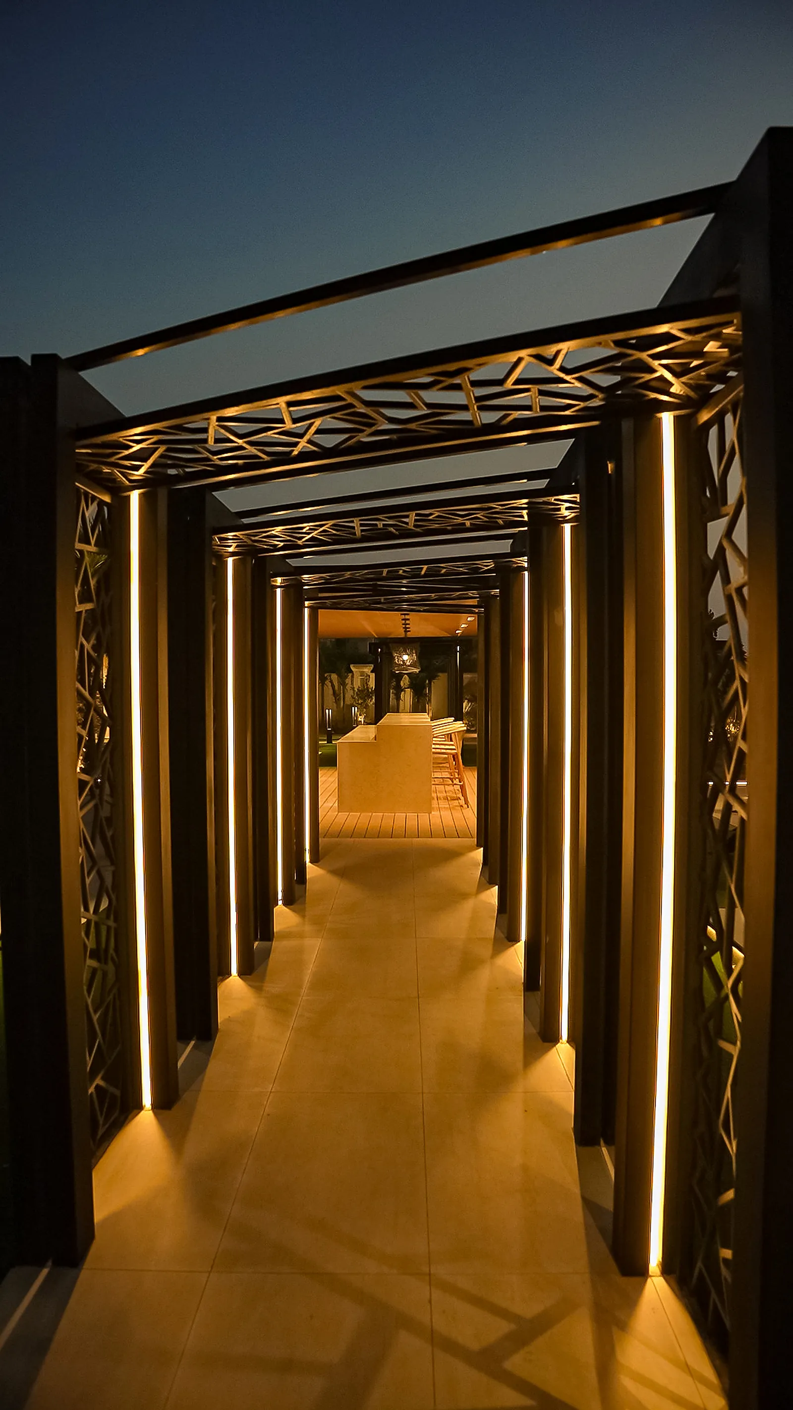 The pergola walk, with vertical linear fittings set into the inside face of each decorative metal frame