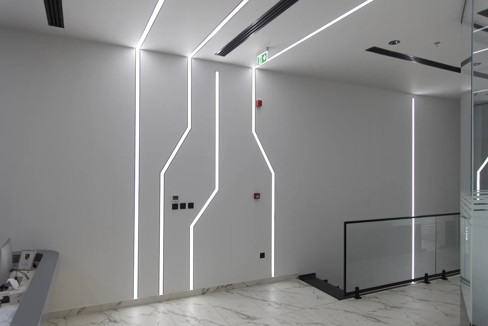 A corridor at Al Weam where a continuous linear run turns several corners and crosses from the wall onto the ceiling