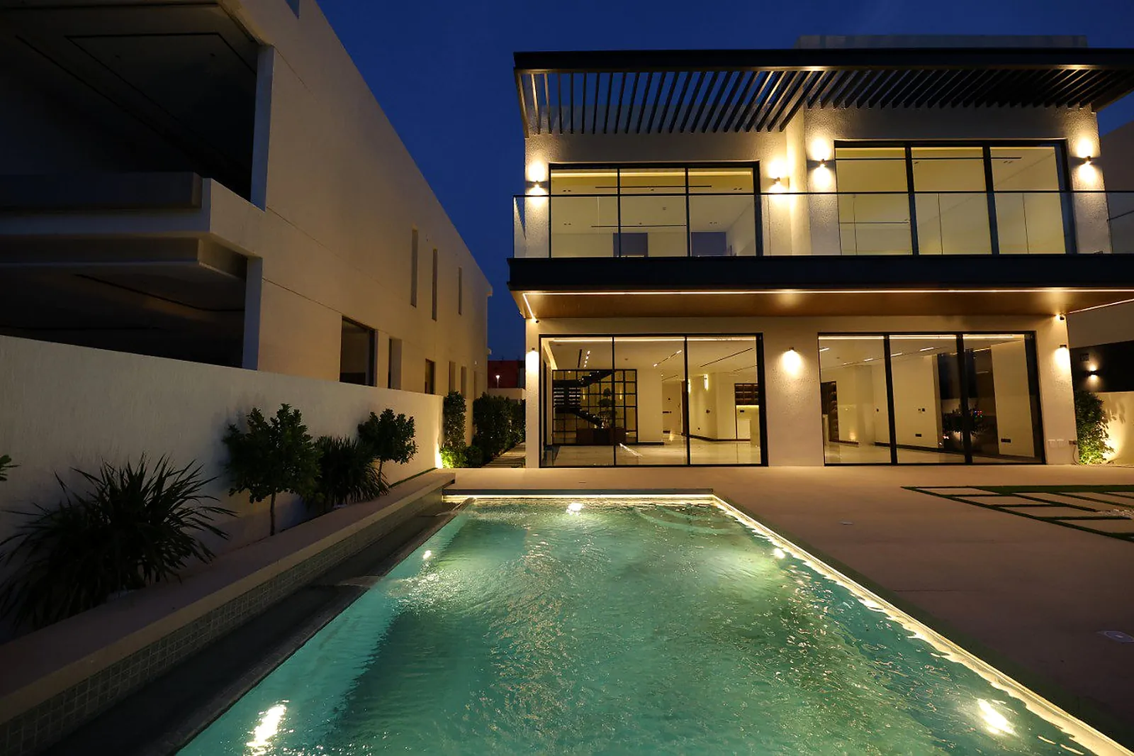 Up-and-down wall fittings along the first-floor piers and a concealed line under the slab, on the pool elevation of the Alkhafaji villa