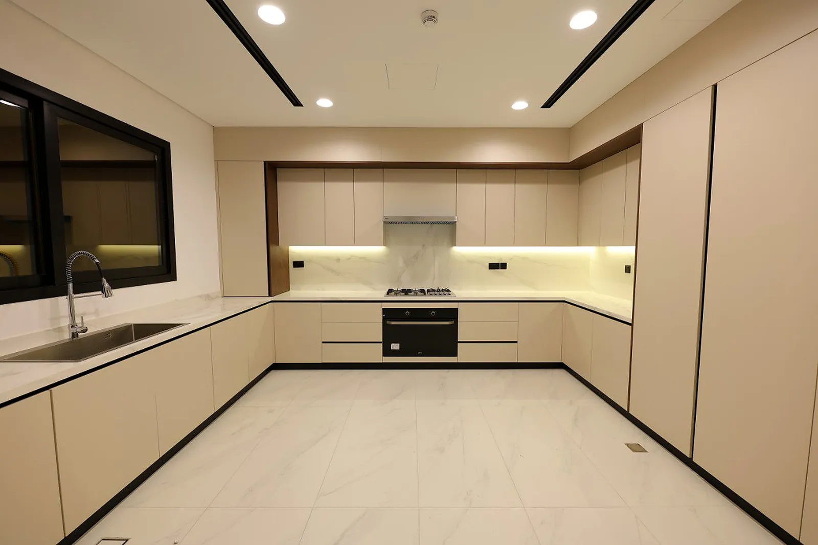 A concealed strip under the upper cabinets washing the marble splashback in the Alkhafaji working kitchen