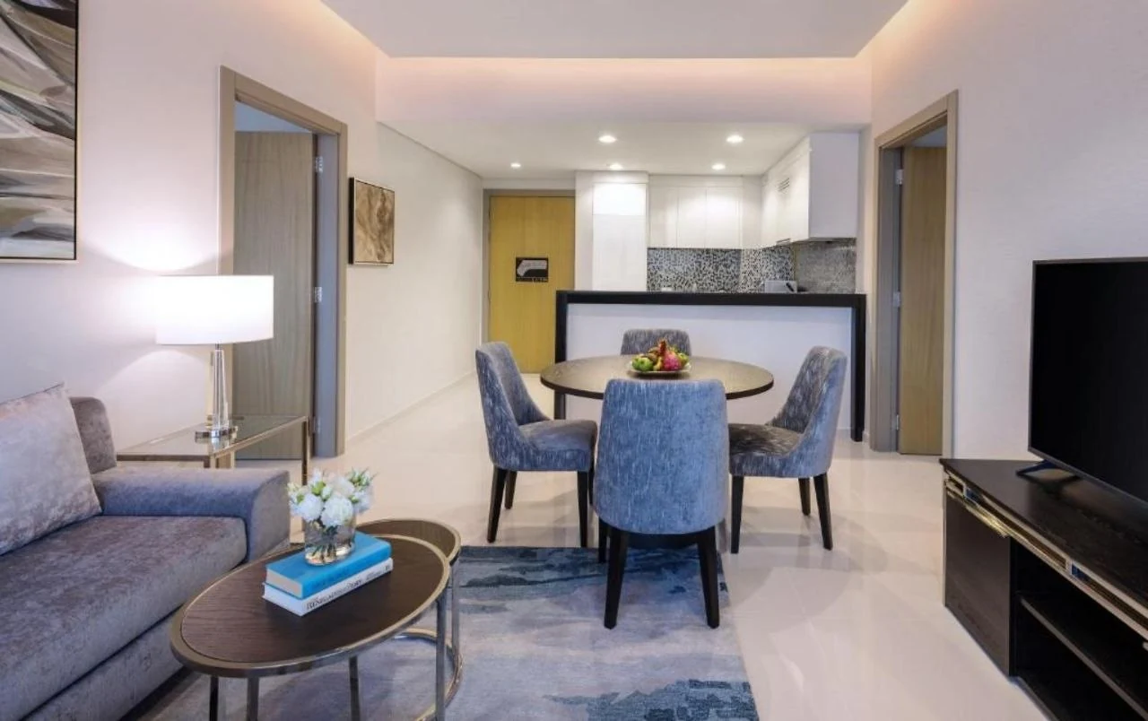 A serviced apartment living and dining room at Aykon City, lit by a cove and a small number of downlights