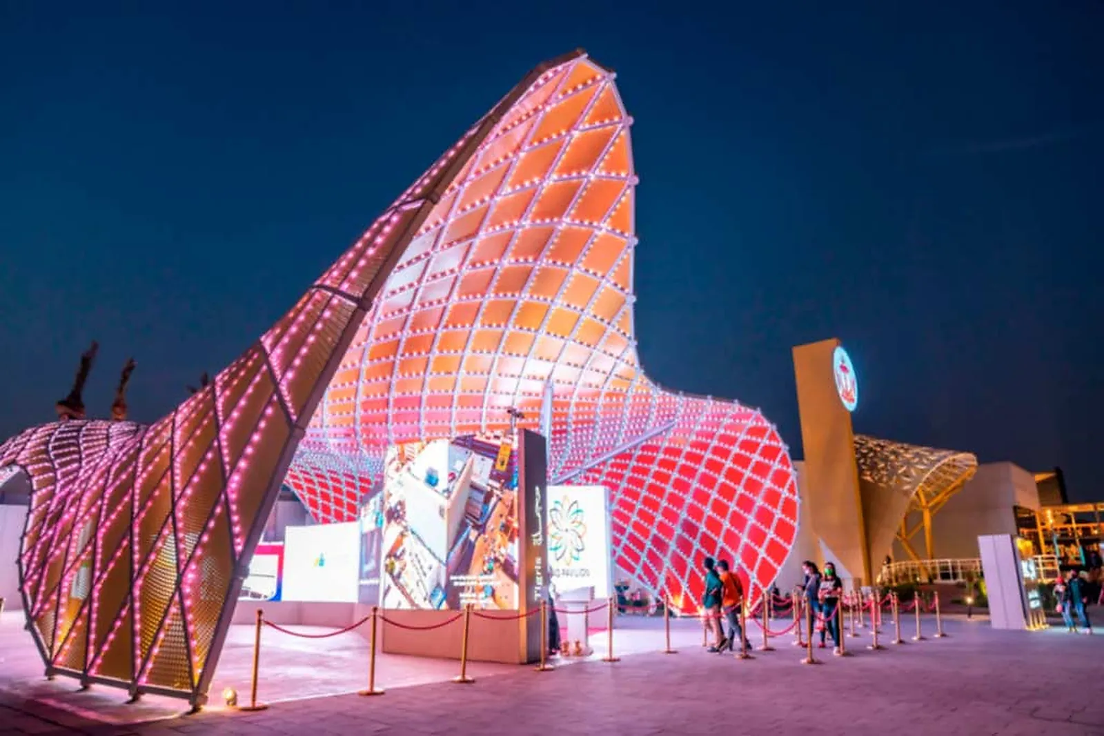 The main entrance to the Iraq Pavilion, the canopy above it lit warm with exhibition panels below