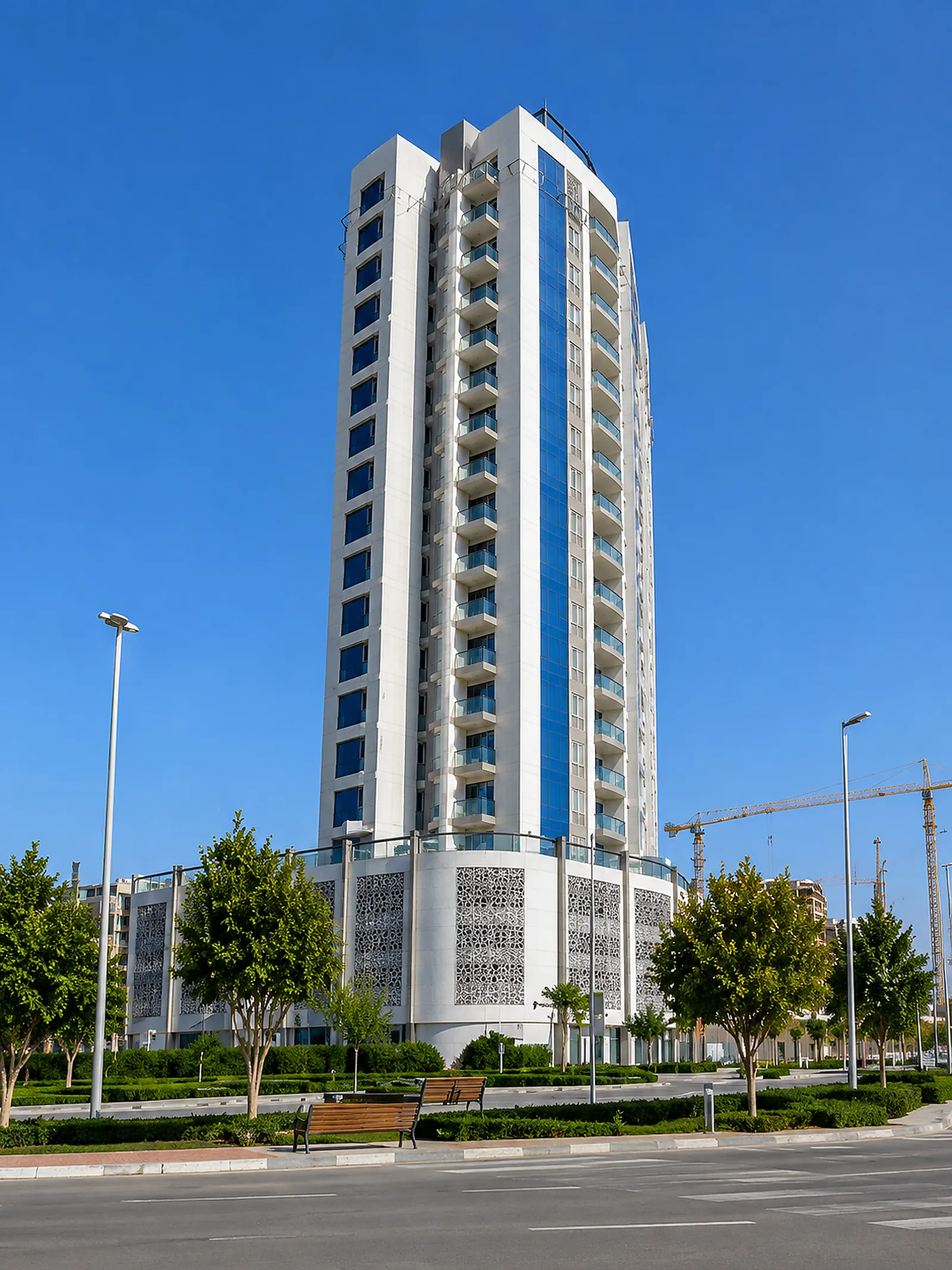 OST Tower by day, showing the curved balcony fronts and the perforated podium screens that carry the lighting