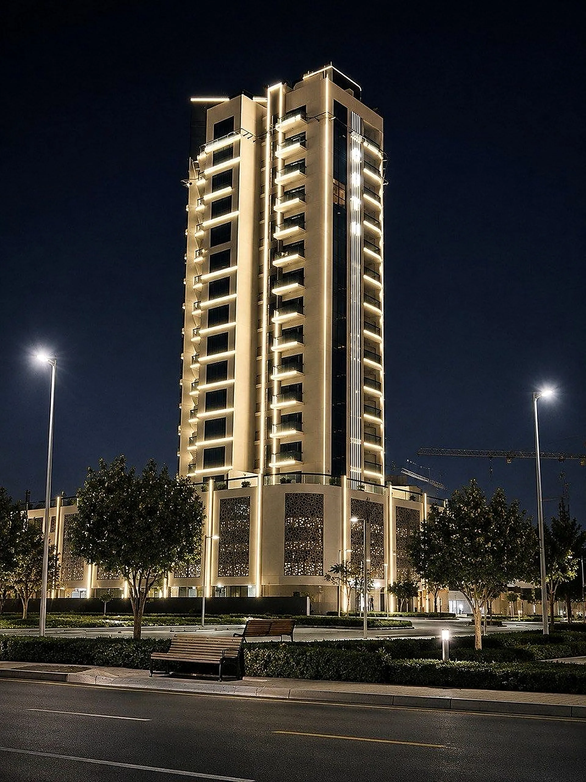 OST Tower at night, warm light following the curved balcony lines and the perforated screens at podium level