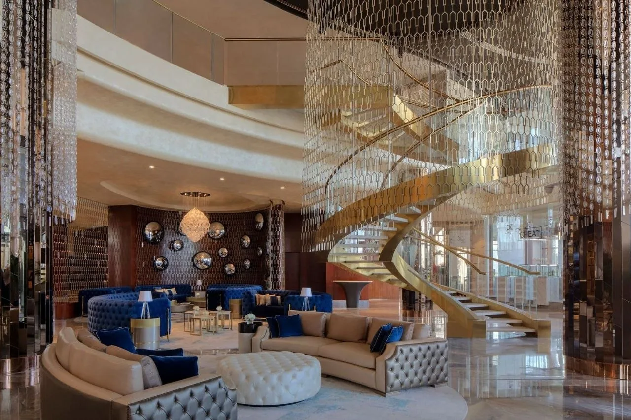 The hotel lobby at Paramount Tower, with a curved staircase wrapped in a full-height curtain of hanging crystal