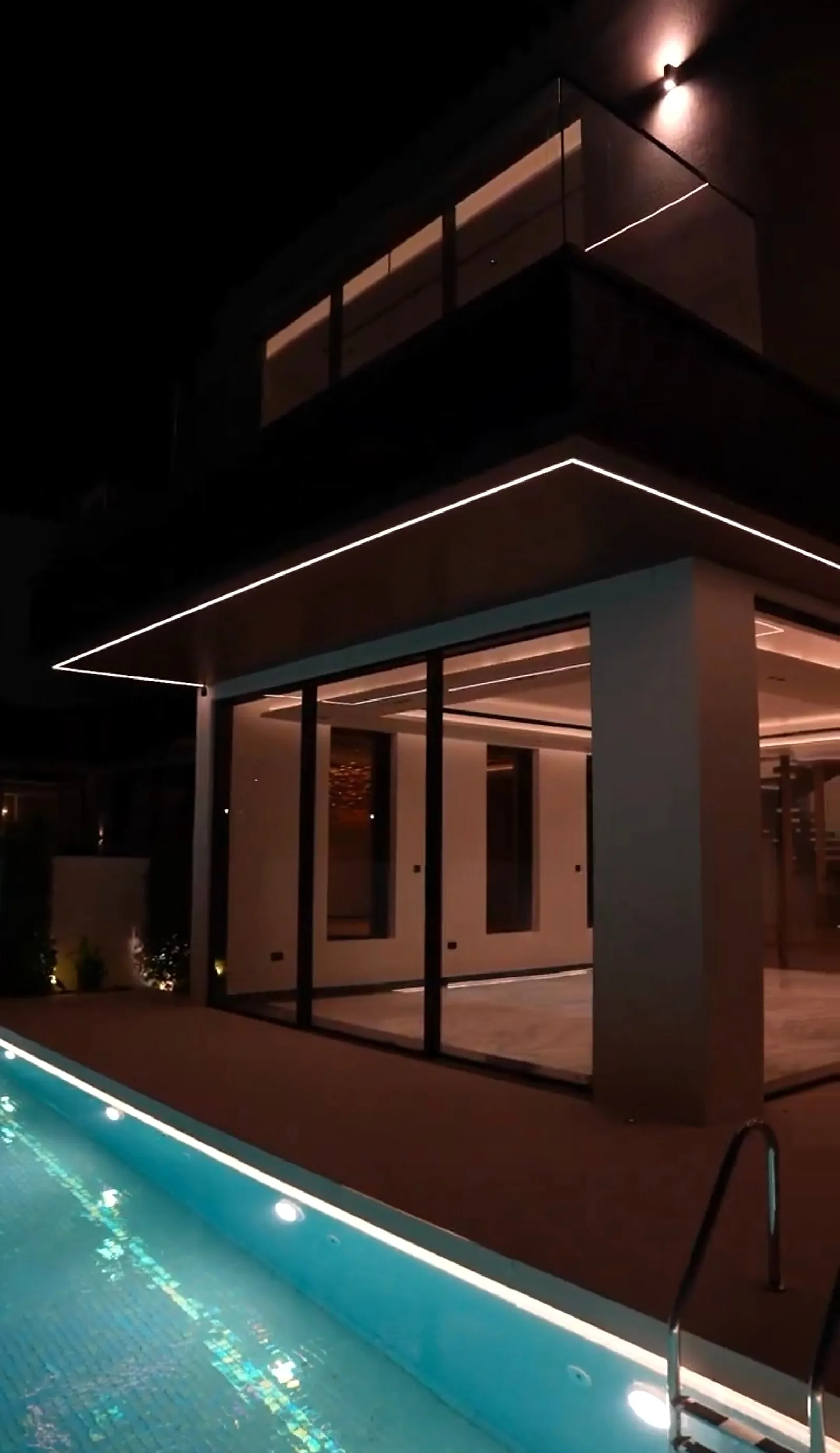 Underwater fittings set into the long wall of the pool, with the soffit line above reflected in the still water