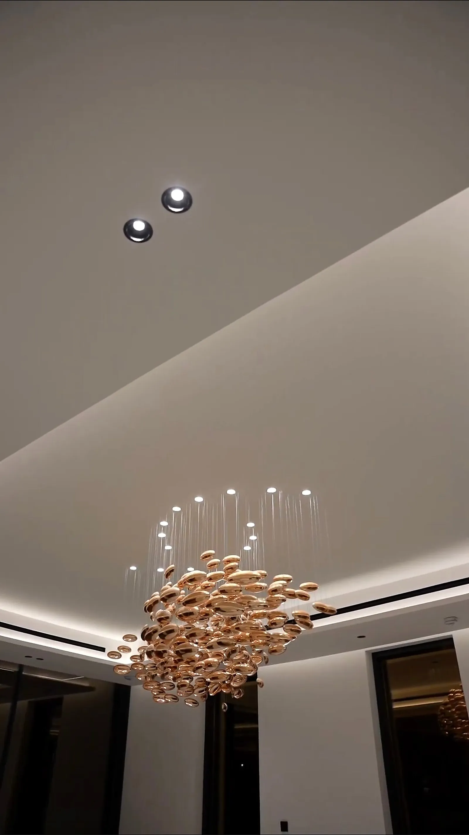 The chandelier from below, its slender gold stems radiating from a central body